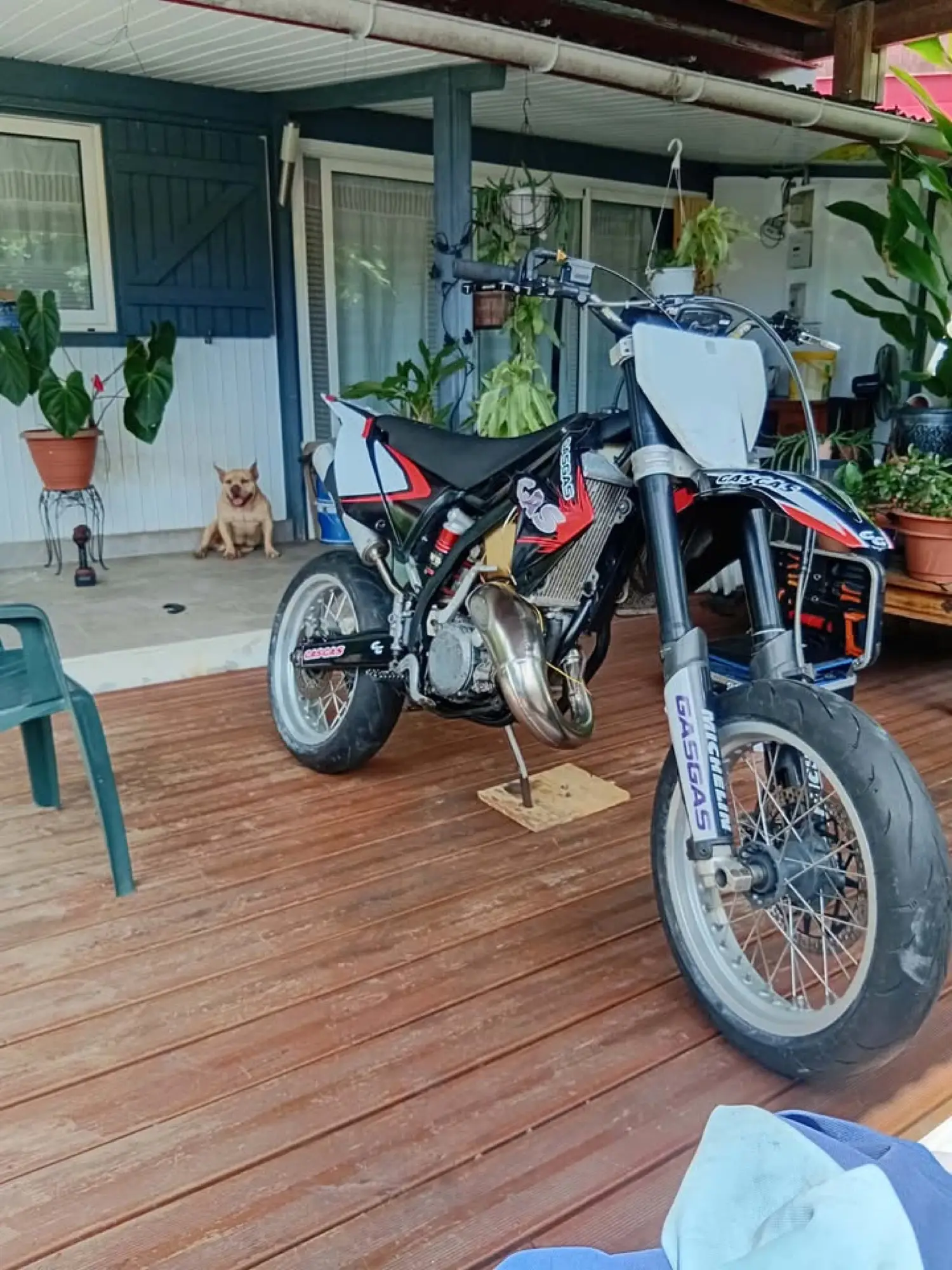 Moto GasGas supermotard équipée d'un kit déco noir, blanc et rouge, sur une terrasse